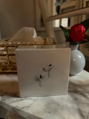 Apple AirPods Pro trådlösa hörlurar - Säljer ett par Apple AirPods Pro i originalförpackning. De är vita, har en stilren och kompakt design och levereras i en snygg box. Perfekta för dig som vill ha grymt ljud, brusreducering och smidig anslutning till din iPhone eller andra Apple-enheter.