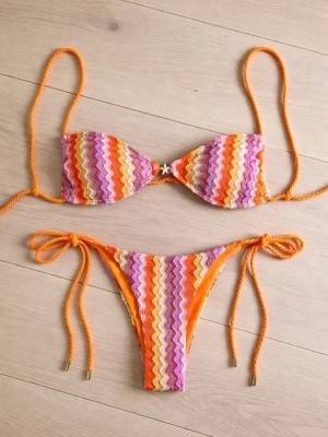 Randig bikini i orange och rosa - missoni vibe - Färgglad bikini med vågiga ränder i orange, rosa, gul och vit. Bikinin har snörning både upptill och nedtill för justerbar passform. Materialet känns mjukt och stretchigt, perfekt för lata dagar på stranden. Missoni vibes.