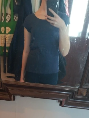 Mörkblå basic t-shirt - En enkel mörkblå t-shirt med rund hals och korta ärmar. Modellen är figurnära och passar perfekt till jeans eller shorts. Tillverkad i mjuk bomull för skön känsla hela dagen.