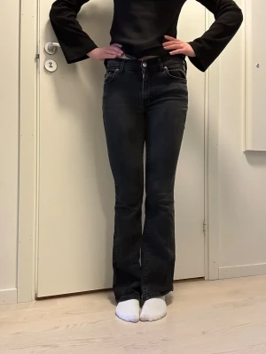 Svarta bootcut jeans  - Säljer ett par svarta bootcut jeans med low/mid  waist. Jeansen har en smal passform upptill och lätt utsvängda ben. Materialet är stretchigt denim som sitter snyggt och bekvämt!