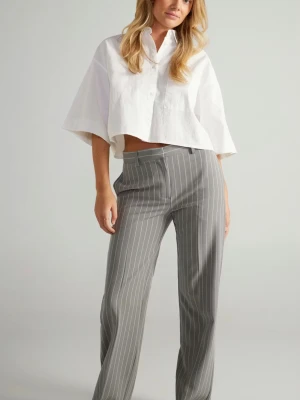 Grå kostymbyxor med vita ränder - Snygga grå kostymbyxor med vita vertikala ränder och rak passform. Byxorna har hög midja och klassisk design, perfekta för en stilren look. Materialet ser ut att vara en blandning av polyester och viskos för en mjuk känsla.