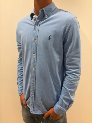 Ralph Lauren - Tja säljer en Ralph Lauren skjorta i färgen ljusblå och storlek s passar 170-180 cm ungefär nypris 1595kr mitt pris 299kr. Inga defekter som hål eller fläckar. Skriv vid fråga eller fundering. 