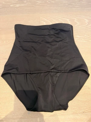 Svart high waist shapewear  - Säljer ett par nya svarta shapewear trosor med hög midja som formar och slätar ut siluetten. Tillverkade i stretchigt och mjukt material för bekväm passform under kläder. 