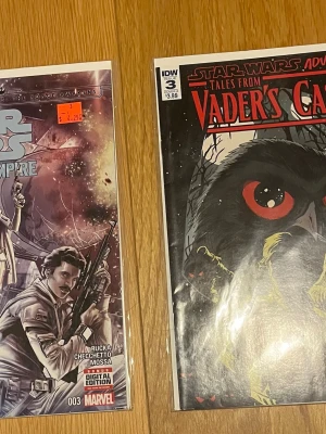 Star Wars serietidningar  - Två Star Wars serietidningar: en från Marvel med Han Solo på omslaget och en från IDW med titeln 'Tales from Vader's Castle'. Färgstarka omslag med rymdtema och illustrationer, perfekta för Star Wars-fans och samlare.