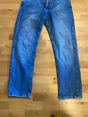 Jack&Jones raka jeans blåa fint skick  - Säljer ett par blå jeans med rak passform och hög midja. Jeansen har fem fickor och stängs med dragkedja och knapp. Tillverkade i kraftigt denimtyg som ger en tidlös look. Perfekta för dig som gillar en enkel och clean stil.