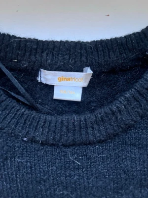 Svart stickad tröja Gina Tricot - Mysig svart stickad tröja från Gina Tricot med rund halsringning och ribbade muddar. Perfekt basplagg till garderoben och enkel att matcha med olika stilar. Tröjan är i mjukt material och har en klassisk, rak passform.