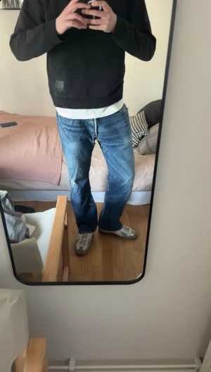 Vintage Levi's jeans - Säljer ett par klassiska blå Levi's jeans med rak passform och slitningar på benet och fickorna. Jeansen har fem fickor, knappgylf och råa kanter vid bensluten. Perfekta för en avslappnad och trendig look. Det är bara hör av sig om ni har frågor!!!!
