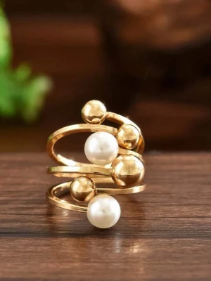 Guldfärgad ring med pärlor ifrån iokiu - Trendig guldfärgad ring med spiralformad design, dekorerad med vita pärlor och guldfärgade kulor. Ringen har en modern och stilren look som sticker ut och passar perfekt för dig som gillar unika accessoarer.
