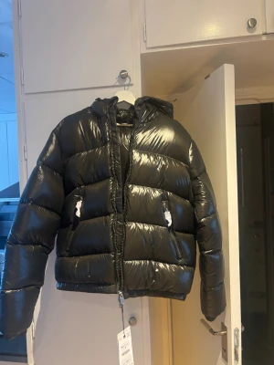 Mörkgrön herr pufferjacka med huva storlek M - Helt ny mörkgrön pufferjacka i Herr modell från Zara i storlek M. Jackan har glansigt material, dragkedja framtill, två fickor med dragkedja och en stor huva. Superfin men tyvärr liten i storleken därav säljer jag vidare❤️Superpopulär och helt slutsåld på hemsidan. Lapp sitter kvar samt skydd på dragkjedjorna osv. Skriv för fler bilder! Pris går självklart att diskutera😊💕