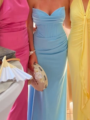 Balklänning - Säger min balklänning. Elegant ljusblå långklänning med draperad midja och axelbandslös, hjärtformad urringning. Klänningen har en figurnära passform och är perfekt för speciella tillfällen. Använt en gång. Skriv för mer information eller bilder💕