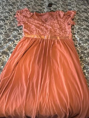 Rosa långklänning med spetsdetaljer - Romantisk rosa långklänning från shein med vacker spets upptill, korta puffärmar och markerad midja med satinband. Kjolen är mjukt fallande och ger en elegant siluett. Perfekt för speciella tillfällen.