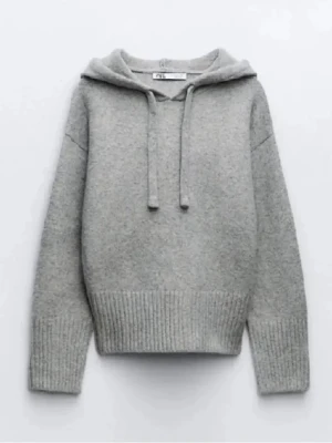 Grå hoodie med huva från Zara - Mysig grå hoodie från Zara med huva och dragsko. Tillverkad i mjukt stickat material och har breda ribbade muddar vid ärmslut och nederkant. Perfekt för en avslappnad och stilren look.l Kan diskutera pris🤗