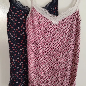 Blommiga linnen med spetsdetaljer - Två suuuper söta linnen med blommigt mönster och spetsdetaljer vid halsringningen🌸⭐️. Ett i rosa och vitt, och ett i mörkblått.