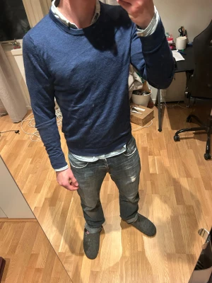 Marinblå stickad tröja These Glory Days - Snygg marinblå stickad tröja från These Glory Days med slim modell. Den är i storlek M och passar perfekt med en skjorta under. Hör av er vid funderingar 