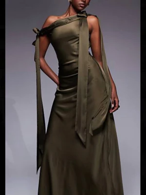Olivgrön långklänning offshoulder - Snygg olivgrön långklänning med offshoulder-design och långa ärmar. Klänningen har en draperad urringning och är tillverkad i ett mjukt, glansigt material som ger en elegant look. Perfekt för dig som vill sticka ut med en unik och trendig stil.