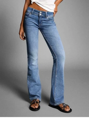 Ljusblå bootcut jeans - Snygga ljusblå bootcut jeans från bershka med klassiska kontrastsömmar och dubbla knappar i midjan. Jeansen har fickor med lock och knapp bak. Aldrig använt och lappen kvar