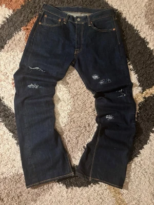 Bootcut Levi’s  - Säljer dessa nya Levi’s 501:or som jag sytt om och gjort slitningar på sedan sytt över igen, har tyvärr inga taggar men utöver det väldigt nya.   Storlek: W33 L32  Laidout liggandes(Mått): Midja: 42 cm Längd(utsidan): 106 cm Nedre bredd(botten): 26 cm  Kondition: 10/10💯  Fraktar samma dag eller dagen efter✅  swag rap streetwear baggy vintage skate hiphop y2k affliction archive underground avant garde japan style OG 2000s flared washed affliction jeans drip oldmoney denim archive stockholm vintag