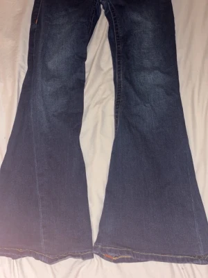 Blå bootcut jeans från True Religion - Säljer ett par true religion jeans i modellen joey low rise flare som är i storlek 28. Har försökt sy upp dom men det blev inte så fint annars är dom i som nya, använda 2 gånger. Dom passar mig som är 164💗💗
