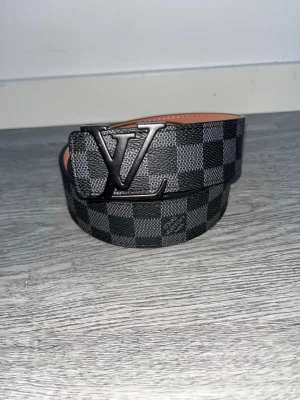 L-bälte - Snygg bälte ifrån märket L som kommer med klassiska monogram mönstret, passar vilken outfit som helst. Strl:110cm