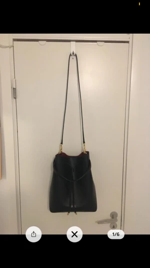 Lauren Ralph Lauren Bucket Bag  - Stockholmstil väskan är som ny i en bra skick, den är svart röd med guld detaljer. En äkta läder fårskinn!!! (Priset kan diskuteras) 