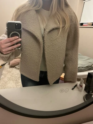 Beige teddyjacka  - Teddy kappa från Gina tricot som är sparsamt använd. Perfekt nu när det börjar bli lite varmare. En knapp sitter löst skriv för fler bilder. 