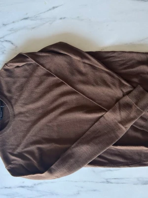 Brun stickad tröja från Matinique - Snygg brun stickad tröja från Matinique. Tröjan har rund halsringning och långa ärmar med ribbade muddar. Perfekt för lager-på-lager och enkel att matcha med jeans eller chinos.