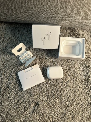 AirPods Pro 3 - Säljer ett par vita Apple AirPods Pro med trådlöst laddningsetui. Hörlurarna har en stilren och kompakt design i blank plast och levereras med flera silikonpluggar för bästa passform. Originalförpackning och tillbehör medföljer.