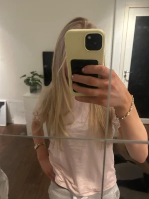 Ljusrosa basic t-shirt i bomull - Enkel och stilren ljusrosa t-shirt i mjuk bomull. T-shirten har rund halsringning och korta ärmar, perfekt för en avslappnad look. Passformen är normal och materialet känns skönt mot huden.