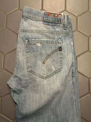 Ljusblå slitna jeans från Dondup - Säljer ett par ljusblå jeans från Dondup med slitningar. Väldigt bra skick. Modell George, storlek 34. Hör av er vid frågor!