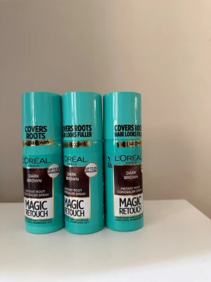 L'Oréal Magic Retouch mörkbrun spray - Tre flaskor L'Oréal Paris Magic Retouch Instant Root Concealer Spray i färgen Dark Brown. Perfekt för att snabbt täcka utväxten mellan färgningar. Smidig sprayflaska i turkos plast med brun etikett.