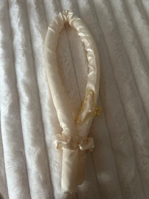 Ljusgul satin värmerulle för håret - Säljer en ljusgul värmerulle för håret i mjuk satin. Perfekt för att skapa lockar utan värme. Kommer med en matchande hårklämma i transparent gult och två scrunchies. Enkel att använda och skonsam mot håret.