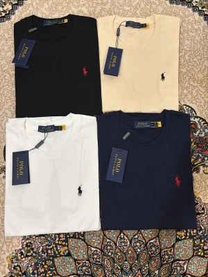 Polo Ralph Lauren t-shirt i flera färger - Klassiska t-shirts från Polo Ralph Lauren i svart, vit, beige och marinblå. T-shirten har rund hals, korta ärmar och ikonisk broderad logga på bröstet. Perfekt basic-plagg i mjuk bomull som funkar till allt.