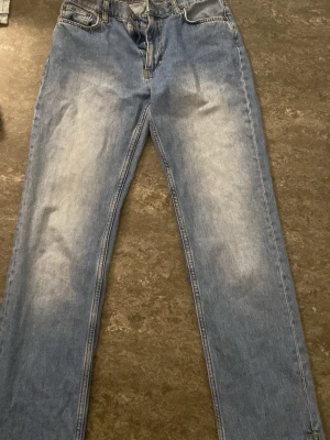 Ljusblå raka jeans med slits från Nelly  - Ljusblå jeans med raka ben och slitsar nertill. Jeansen har klassisk femficksdesign och är tillverkade i denim med lätt tvättad effekt framtill. Perfekta för en avslappnad och trendig look.