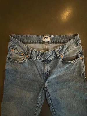 Blå bootcut jeans från 157 - Blå jeans med brunt broderi på bakfickan. Strl L full length.