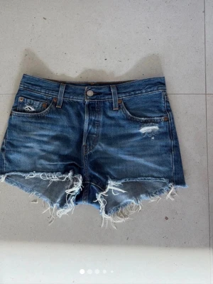 Blå levi’s jeansshorts med slitna detaljer - Säljer mina assnygga levis jeansshorts! Köpta vintage!