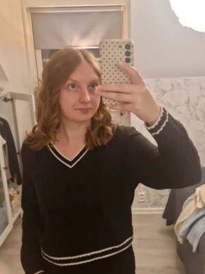 Svart stickad tröja med vita ränder - Svart stickad tröja från H&M Divided med v-ringning och vita ränder vid hals, ärmslut och midja. Skriv vid intresse ❤️