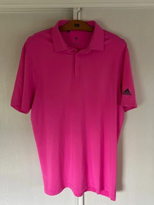 Adidas golfpiké - En rosa golfpiké från Adidas. Säljes då den inte används. Väldigt bra skick utöver ett par sömmar som släppt (se bild 3) inget som syns när den är nedstoppad. Storlek M. Priset går att diskutera! 