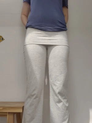 Ljusgrå mjukisbyxor med utsvängda ben - Säljer ett par ljusgrå mjukisbyxor med hög midja och utsvängda ben. Byxorna är i mjukt och stretchigt material, perfekta för en avslappnad stil. Passar dig som gillar bekväma och trendiga plagg.