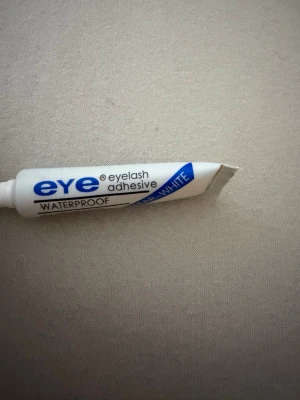 Eye Eyelash Adhesive Clear-White - Vattentätt ögonfranslim från Eye i färgen clear-white. Tuben innehåller 7g och är perfekt för att fästa lösögonfransar. Limmet är lätt att applicera och torkar genomskinligt för ett naturligt resultat.