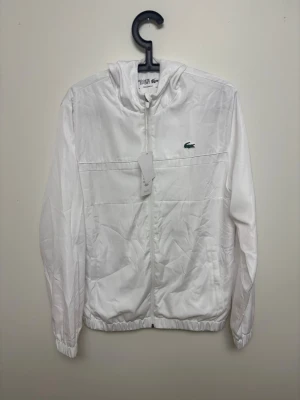 Lacoste Windbreaker  - Säljer min vita Lacoste Windbreaker som är perfekt nu till sommaren | Storlek: M | Fraktar samma dag om köp sker innan 22:00