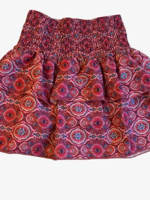 Rosa mönstrad kortkjol med volang - Supersöt kortkjol i rosa med  inbyggda shorts och färgglatt mönster och smock i midjan. Så sjukt snygg till sommaren!✨💕