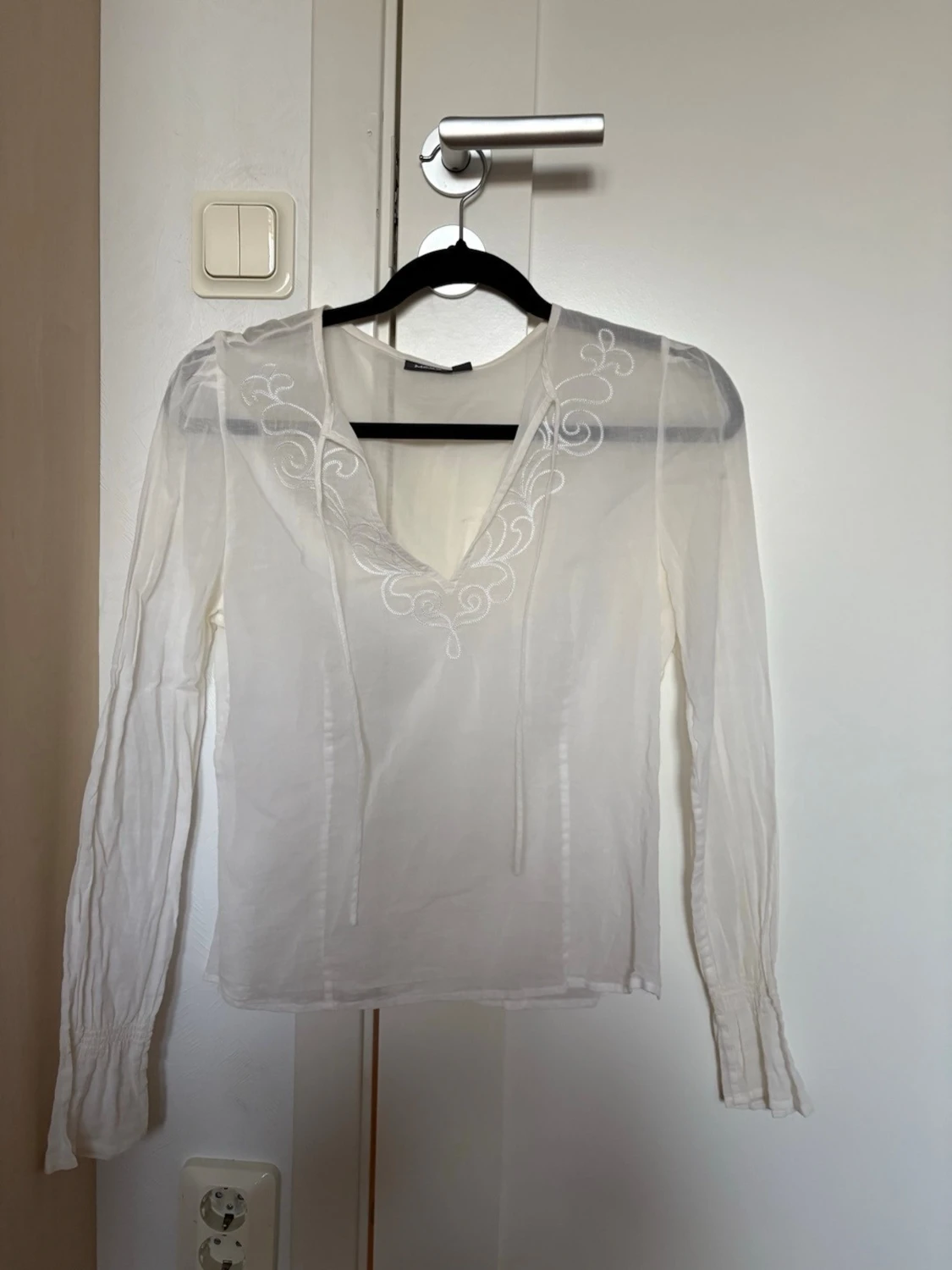 Vit blus med broderi och v-ringning