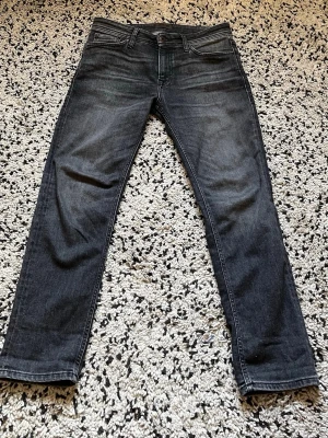 Jeans 30/30 - Snygga mörkblå jeans med raka ben och klassisk femficksmodell. Jeansen har diskreta slitningar framtill och kontrastsömmar. Passar perfekt till en avslappnad stil och är tillverkade i ett mjukt denimtyg.