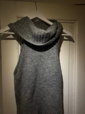 Grå ärmlös stickad polotröja Gina Tricot - Säljer en grå ärmlös stickad polotröja från Gina Tricot. Tröjan har en bred, ribbstickad polokrage och är gjord i ett mjukt, melerat garn. Nypris 350kr . Använd 1 gång 