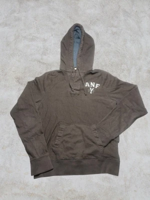Vintage Abercrombie & Fitch hoodie - herr strl L - Säljer en vintage Abercrombie & Fitch hoodie i washed brun färg i storlek L med dubbel knappkrage och ANF brodering på vänster sida av bröstkorgen.  👕 Märke: Abercrombie & Fitch 📏 Storlek: L 🎨 Färg: Washed brun 🧵 Material: 100% bomull 📐 Mått: 72 cm lång, 55 cm bred 📌 Skick: Mycket bra skick (se bilder)  💬 Hör av dig vid frågor 💰 Pris kan diskuteras vid snabb affär 📦 Skickas inom 24 timmar