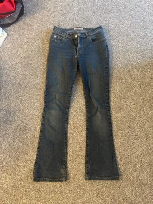Bootcut jeans från miss sixty mörkblå denim - Bootcut jeans från miss sixty i mörkblå denim med klassiska fem fickor och snygga detaljer på bakfickorna. Jeansen har en låg midja och är tillverkade i bomull med lite stretch för skön passform. Perfekt för dig som gillar en tidlös och cool look.