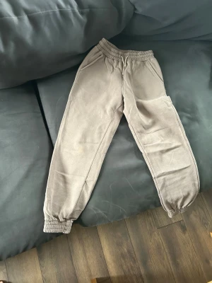 Beiga mjukisbyxor från Lindex - Säljer ett par beiga mjukisbyxor från Lindex med resår i midjan och vid bensluten. Byxorna har två sidofickor och är gjorda i mjukt, skönt material som passar perfekt för chill dagar. Klassisk rak passform och neutral färg som är lätt att matcha.