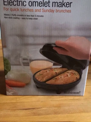 Elektrisk omelettmaskin Rubicson - Elektrisk omelettmaskin från Rubicson som gör två fluffiga omeletter på under 5 minuter. Maskinen har två kammare, non-stick beläggning för enkel rengöring och är kompakt nog att förvara i köksskåp. Perfekt för snabba måltider och brunch.
