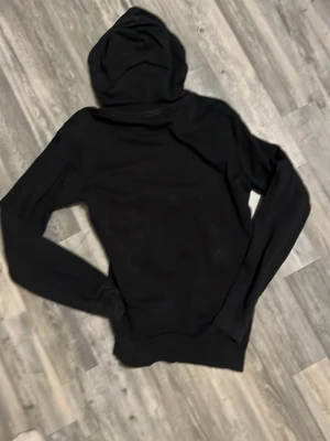 Svart hoodie från Adidas - Säljer en svart hoodie från Adidas med klassisk logga på bröstet. Hoodien har huva med dragsko och en stor magficka framtill. Tillverkad i mjukt material som passar perfekt till chill dagar. Enkel och stilren design som funkar till det mesta.