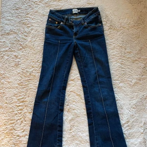 Mörkblå bootcut jeans - Mörkblå bootcut jeans lite slitna längst ner.